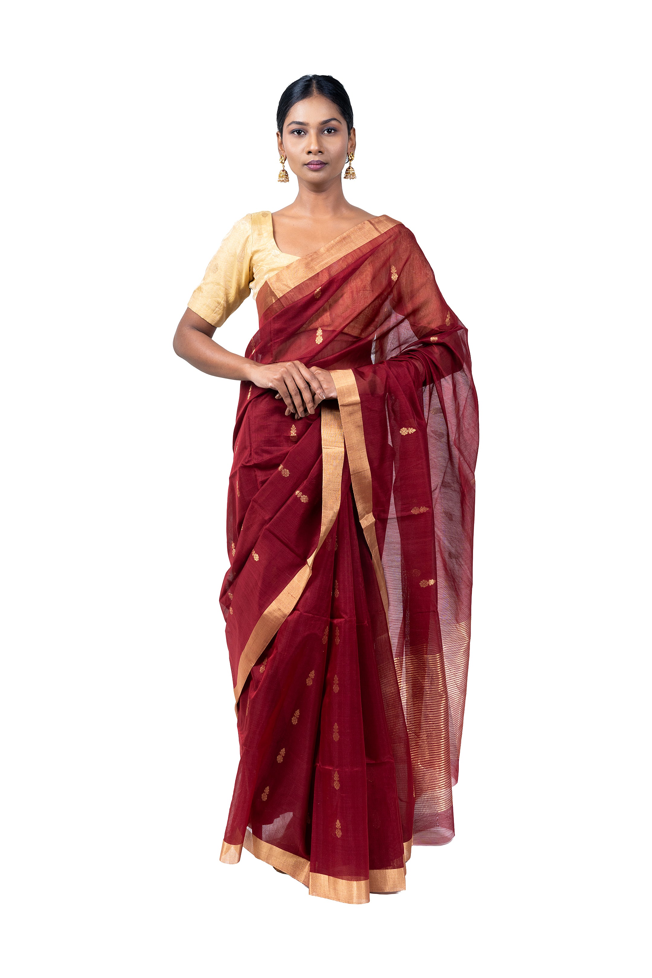 Woman wearing a red saree with gold border on a white background