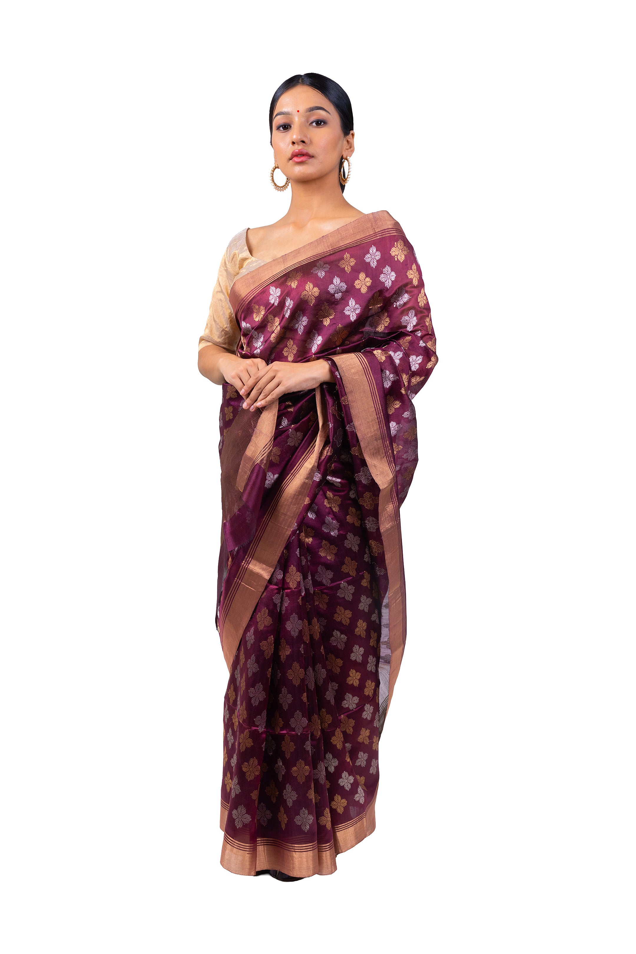 Woman wearing a maroon saree with a floral pattern on a white background