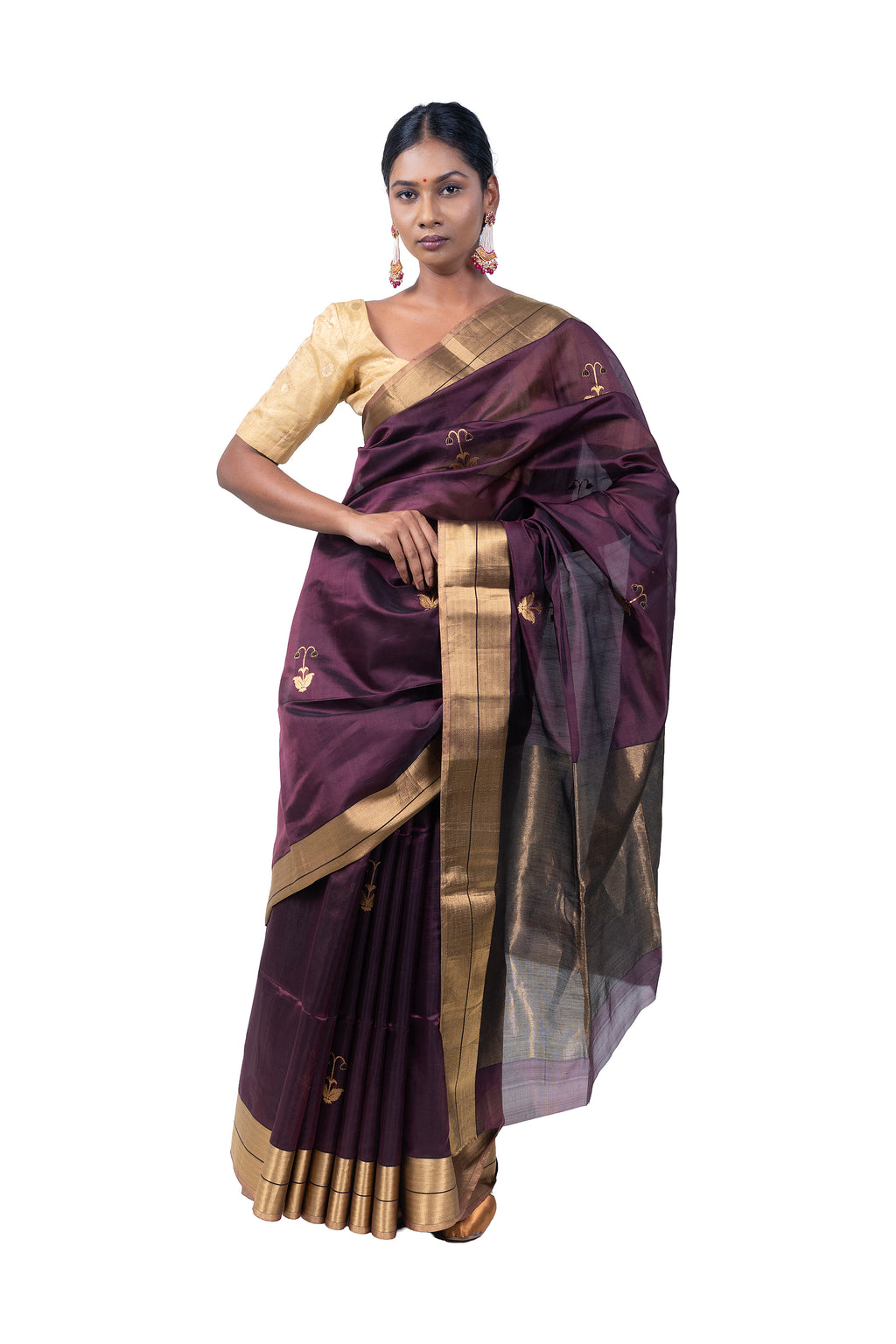 Woman wearing a traditional purple saree with gold border on a white background