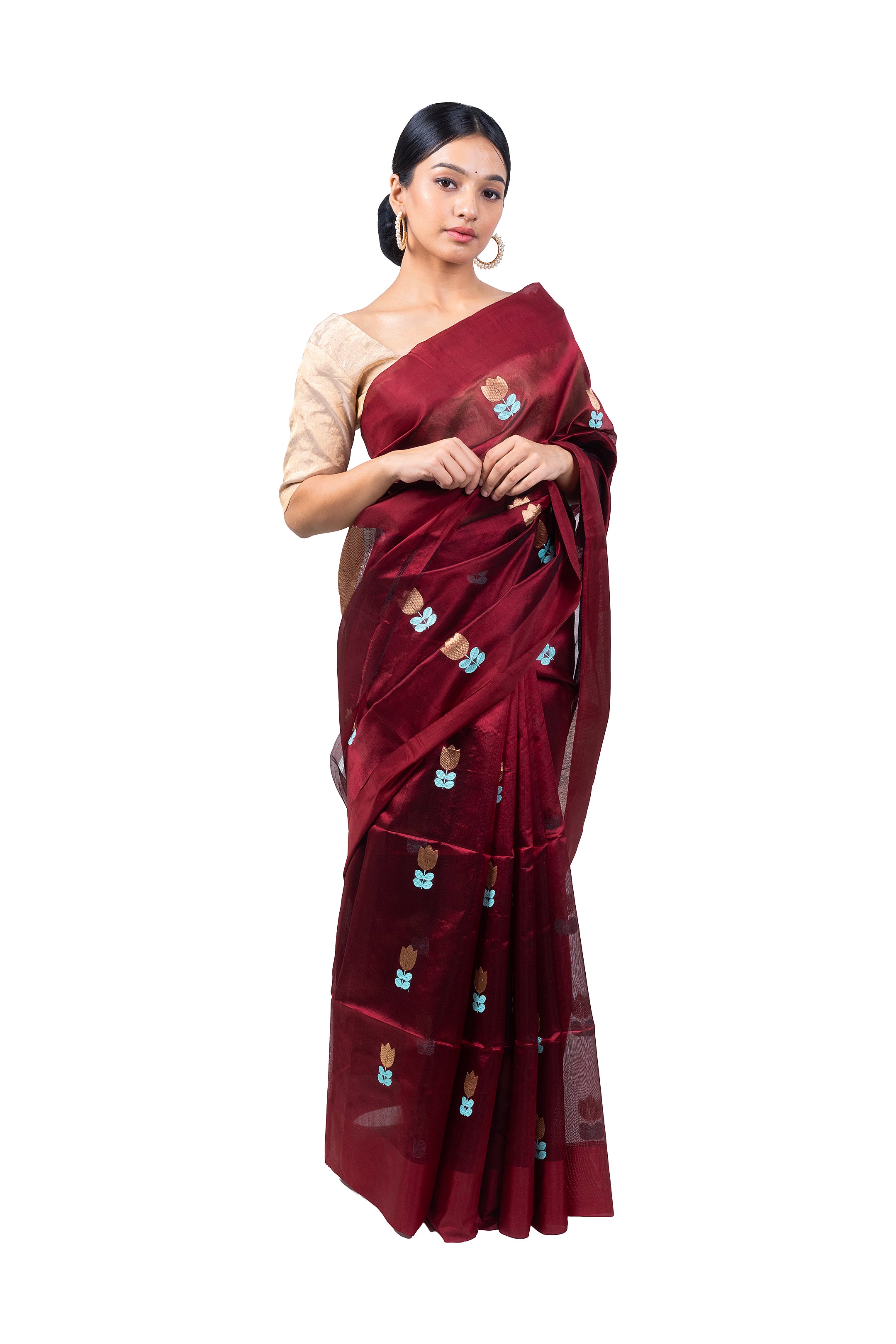 Woman wearing a maroon saree with a white blouse on a white background