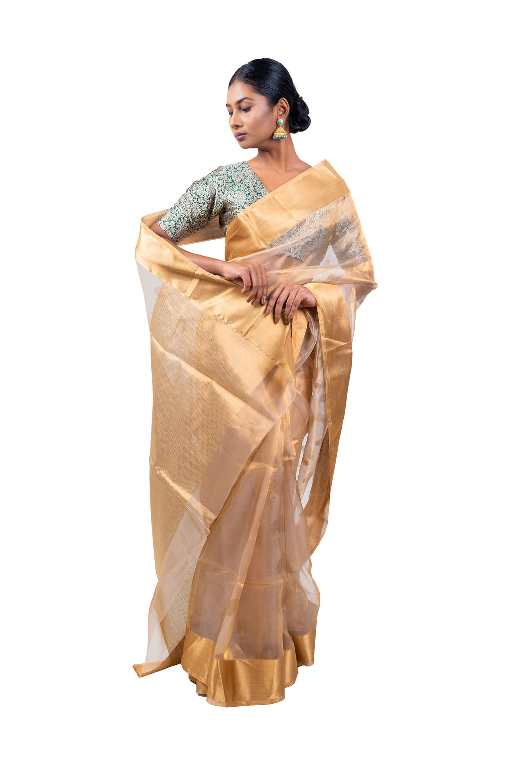 Woman wearing a gold saree with a white background