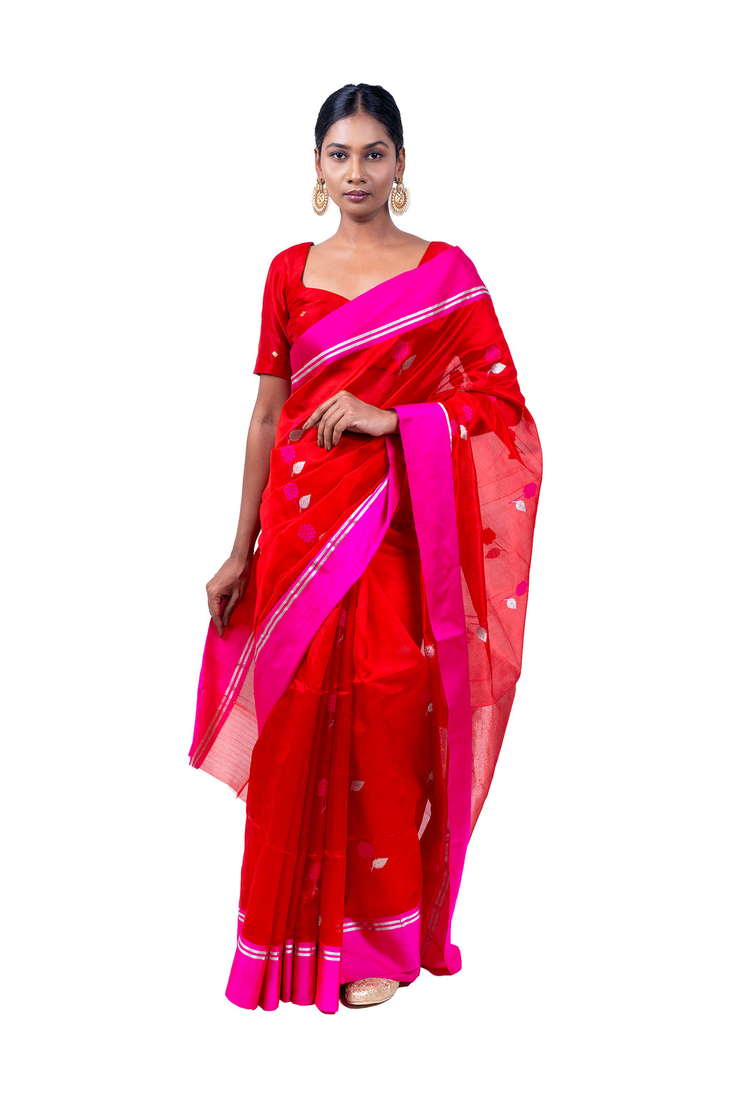 Woman wearing a red saree with pink border on a white background