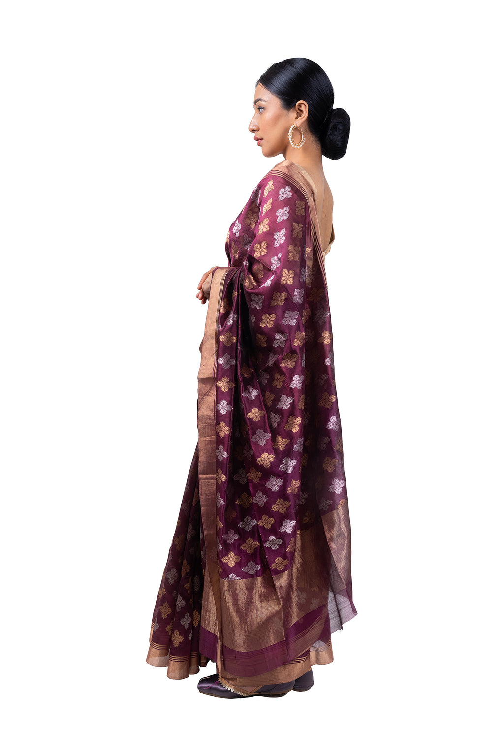 Woman wearing a traditional saree with a floral pattern on a white background