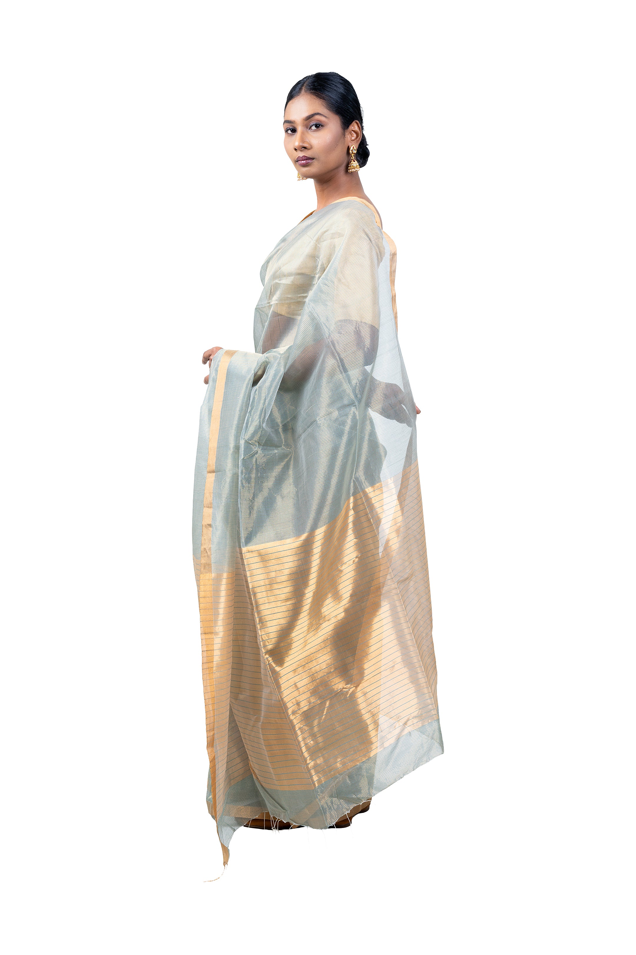 Woman holding a traditional saree with a white and gold pattern on a white background