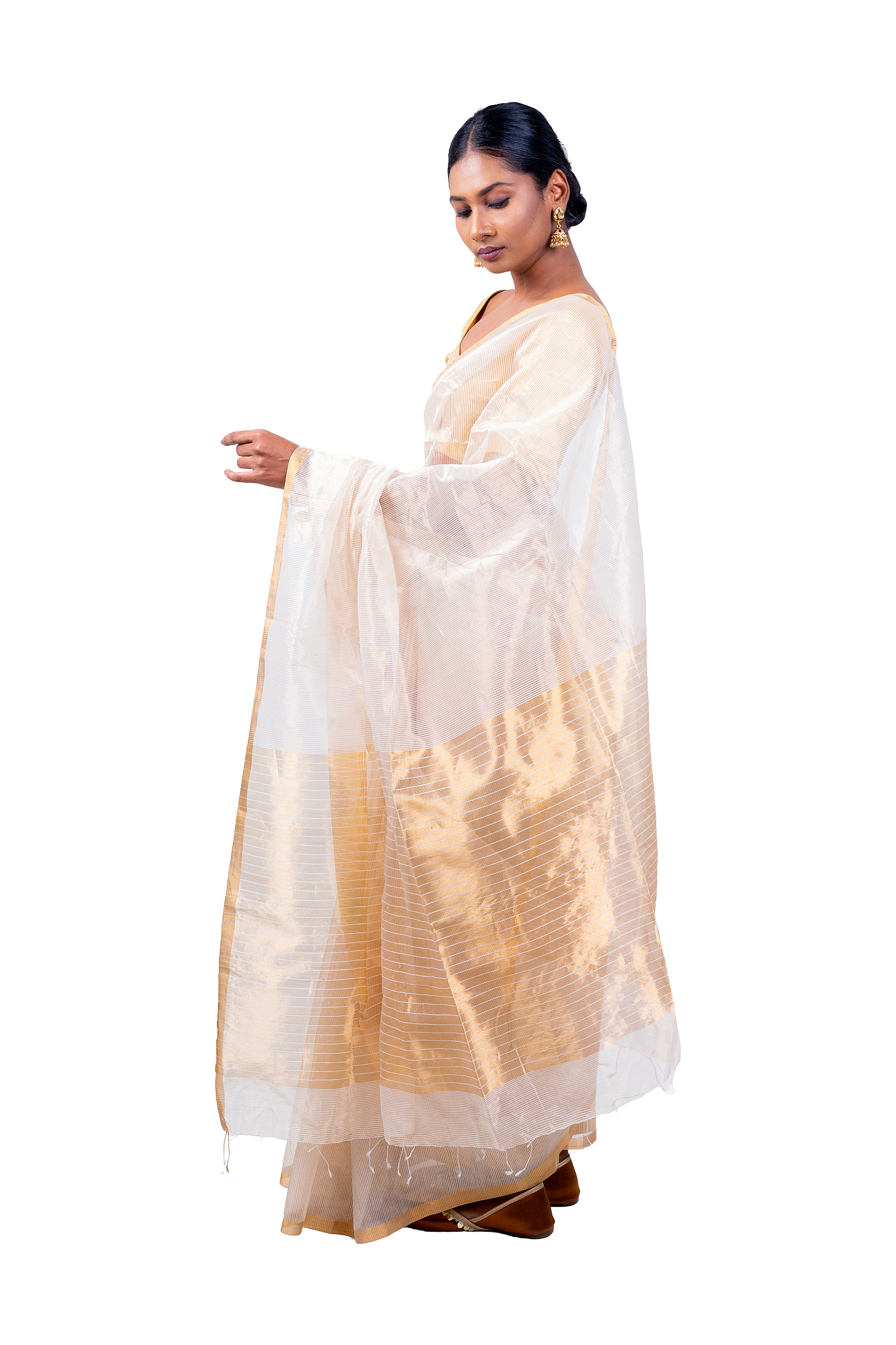 Woman wearing a traditional saree with a white and gold pattern on a white background