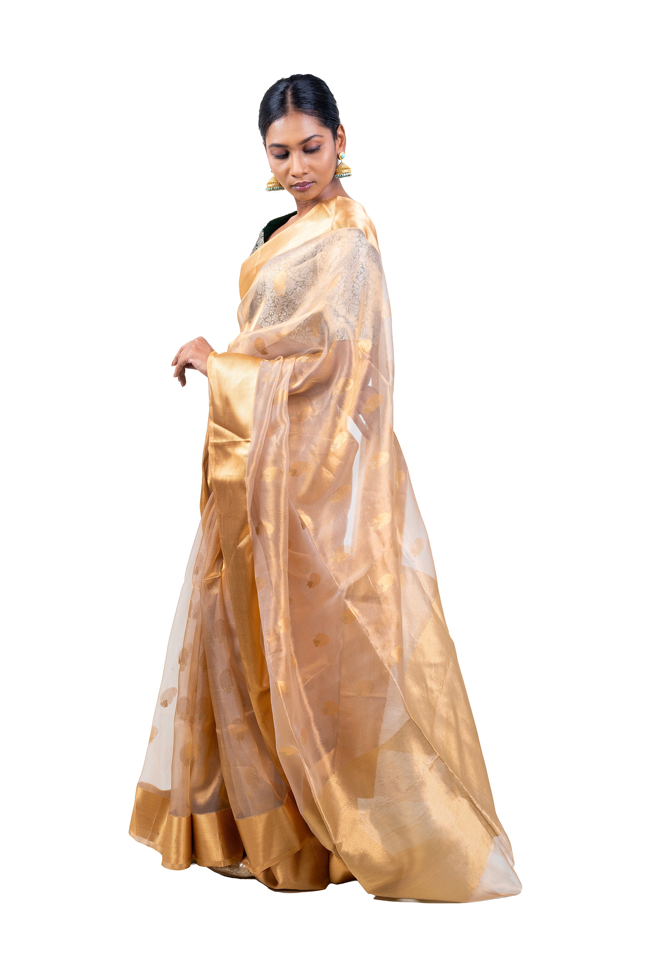 Woman wearing a gold saree with a white background