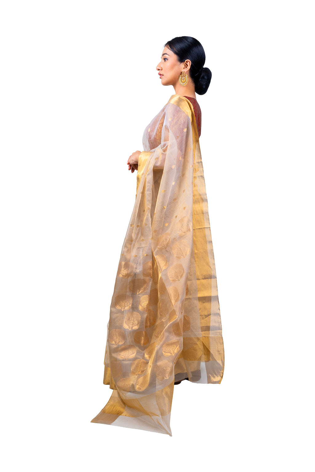 Woman wearing a gold saree with a white background