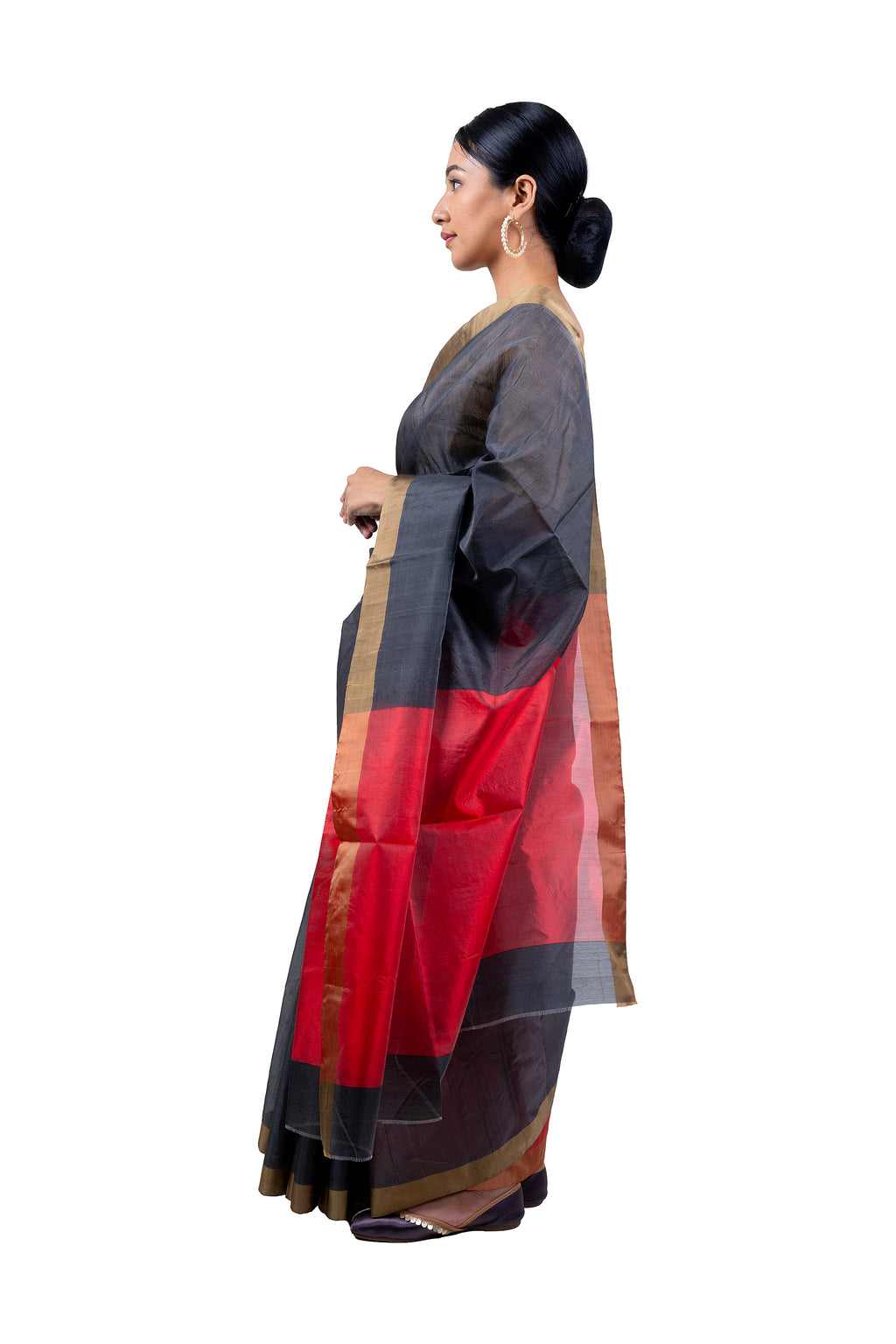 Woman wearing a traditional saree with a red and black pattern on a white background