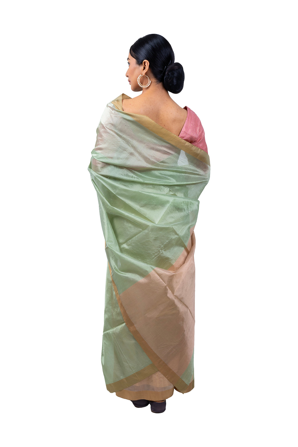 Woman wearing a light green and beige saree on a white background