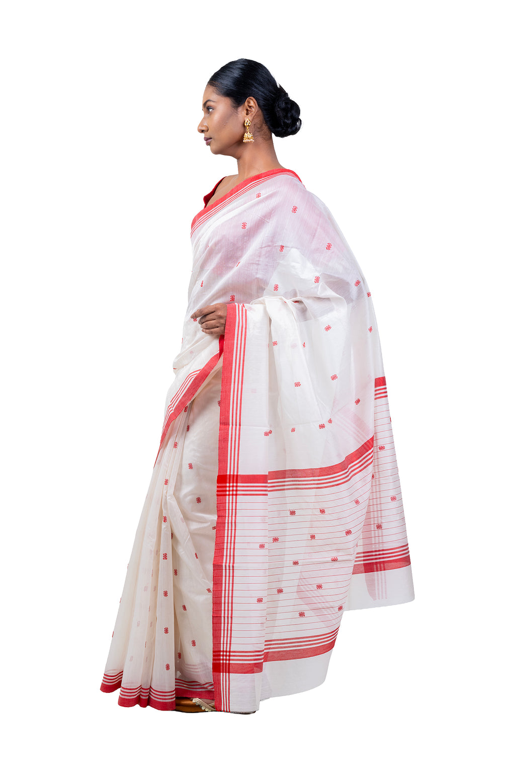 Woman wearing a white saree with red patterns on a white background