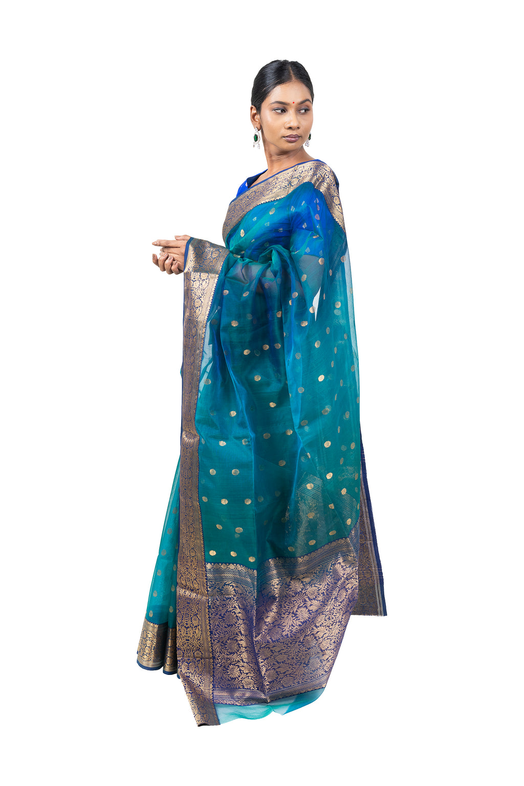 Woman wearing a teal and gold saree with a white background