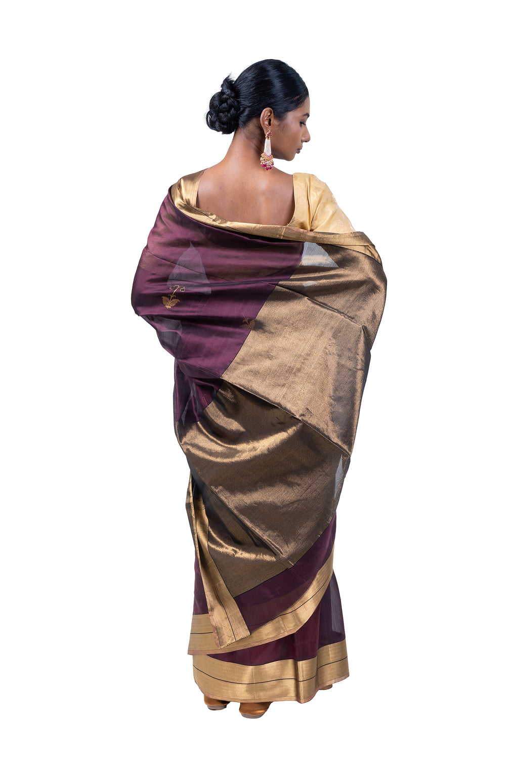 Woman wearing a gold and purple saree on a white background