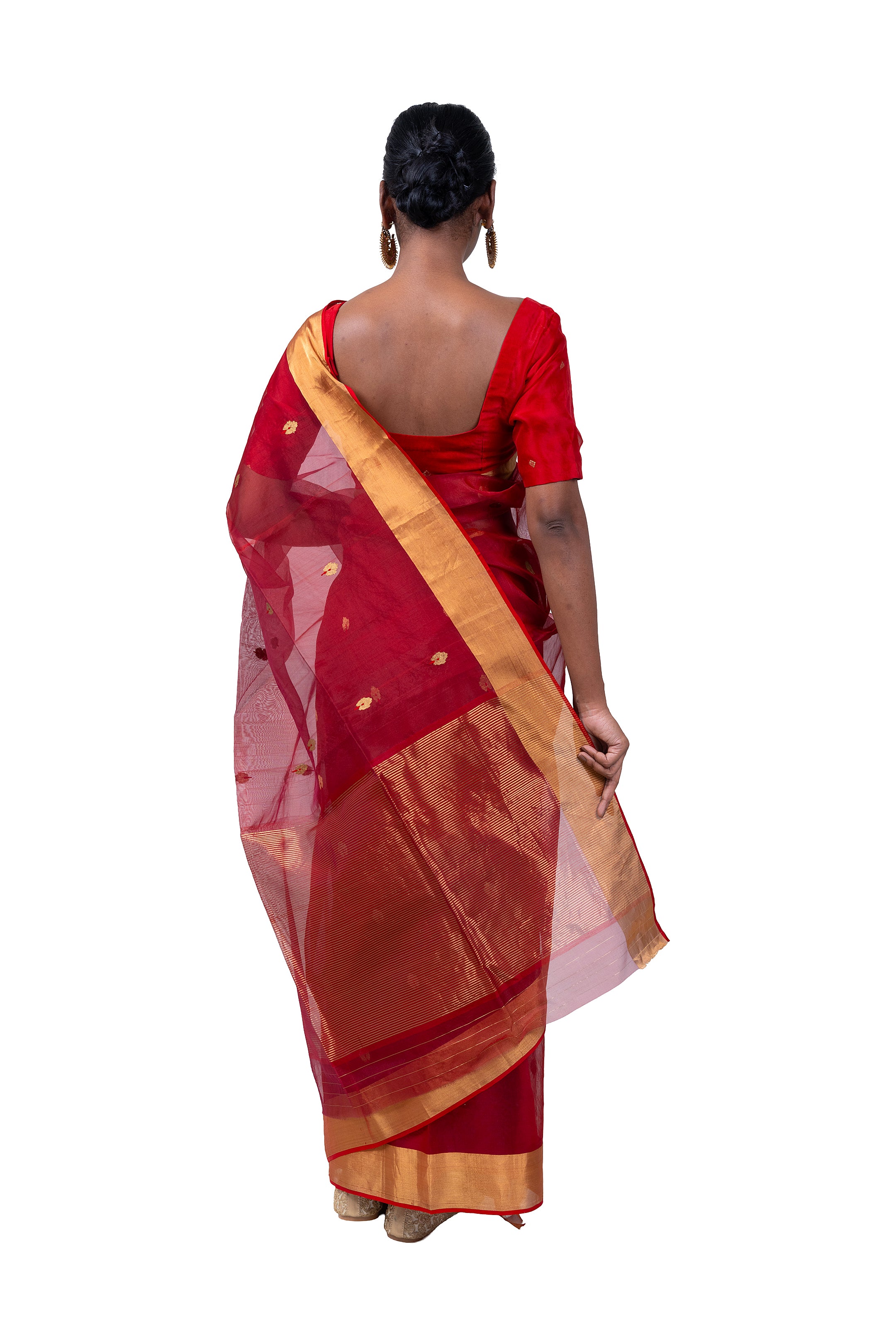 Red saree with gold border worn by a person on a white background