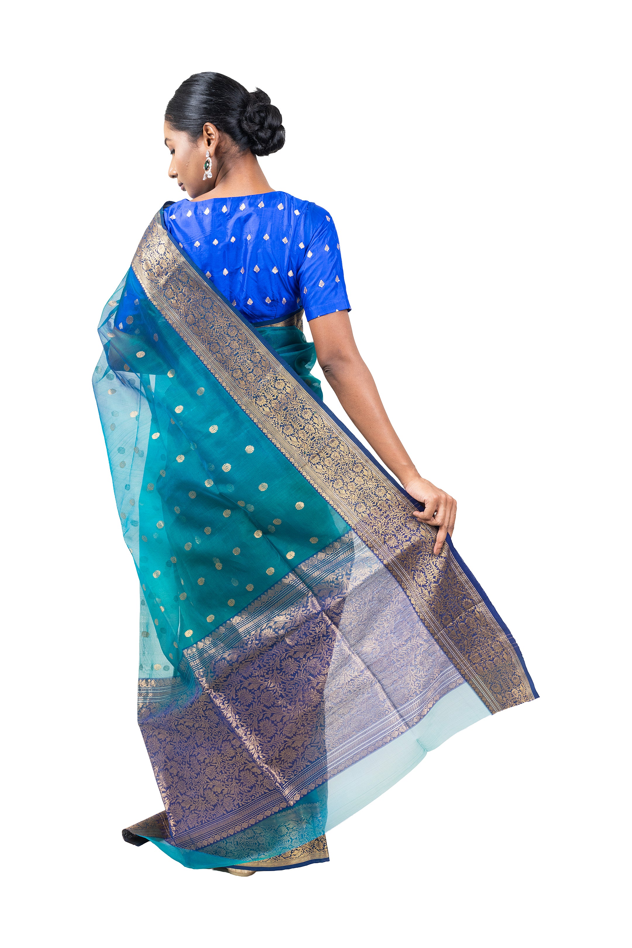Woman wearing a blue and green saree with a white background