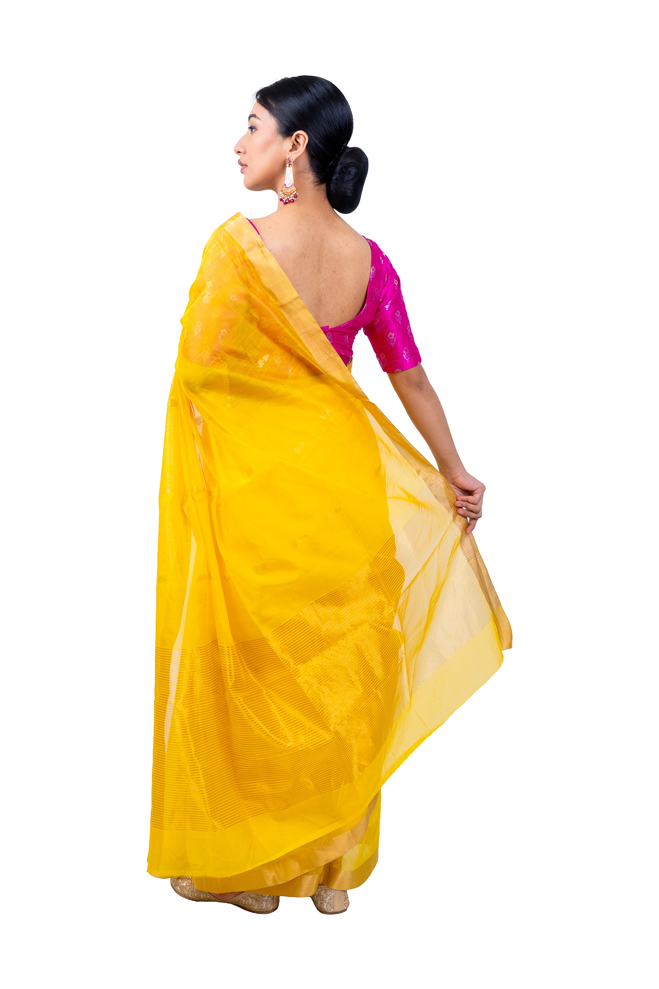 Woman wearing a yellow saree with a pink blouse on a white background