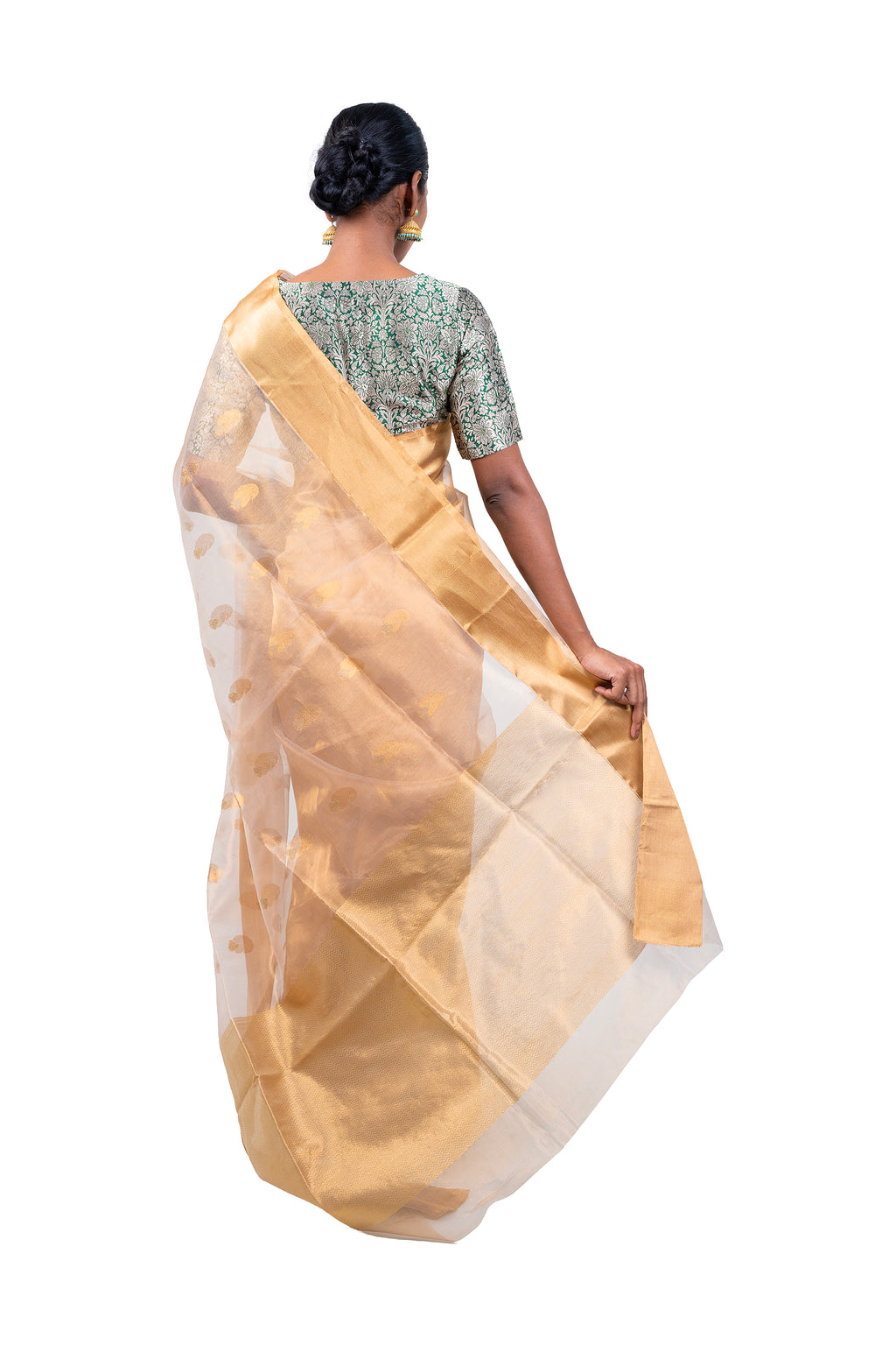 Woman wearing a gold saree with a white background