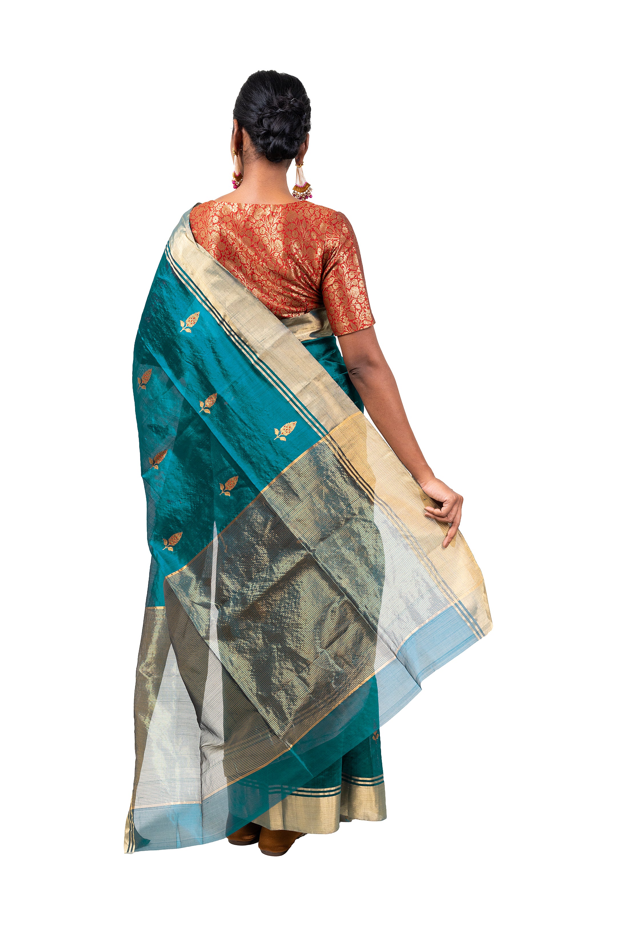 Woman wearing a teal saree with gold patterns on a white background