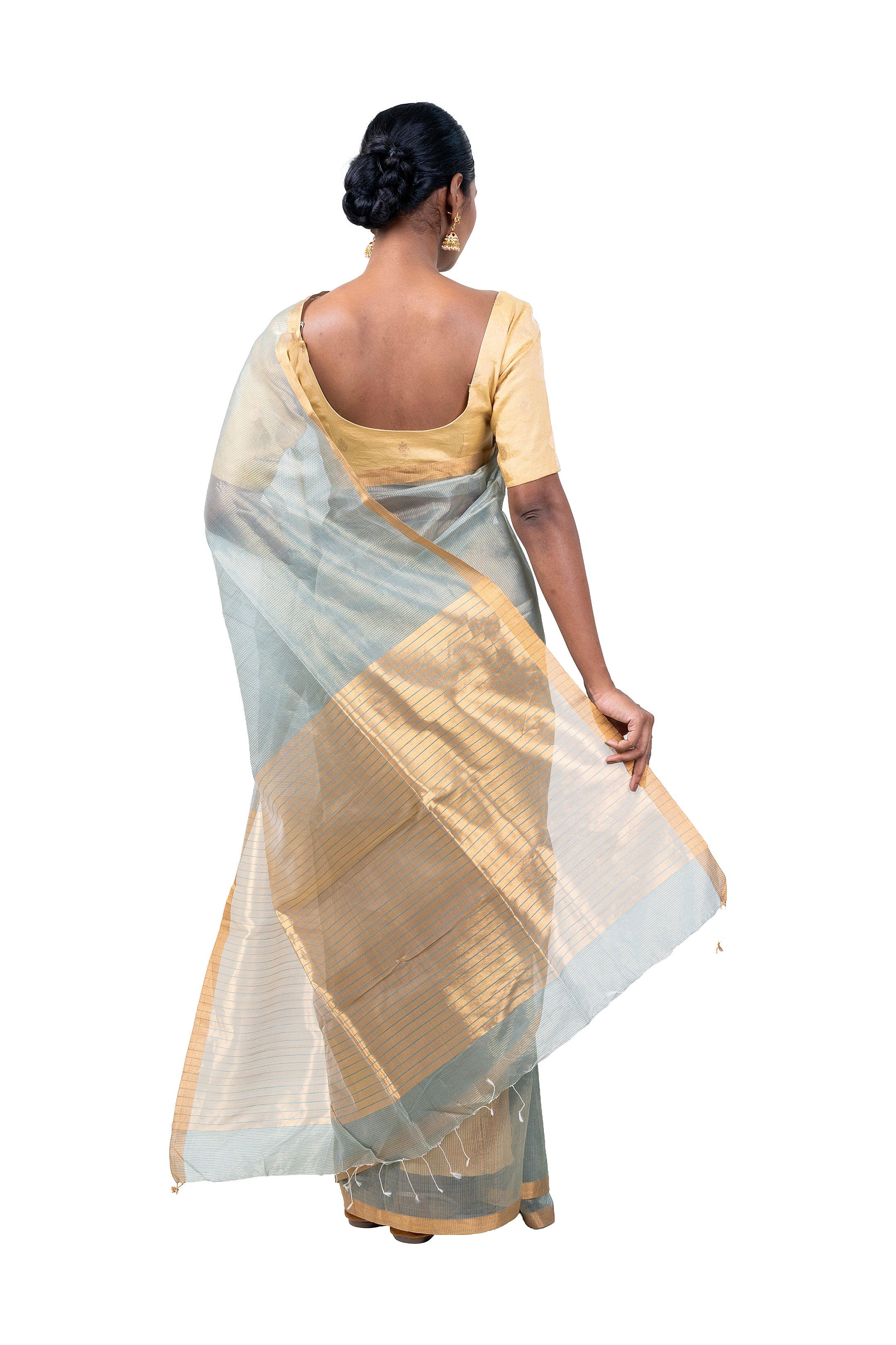 Woman wearing a traditional saree with a white and gold design on a white background