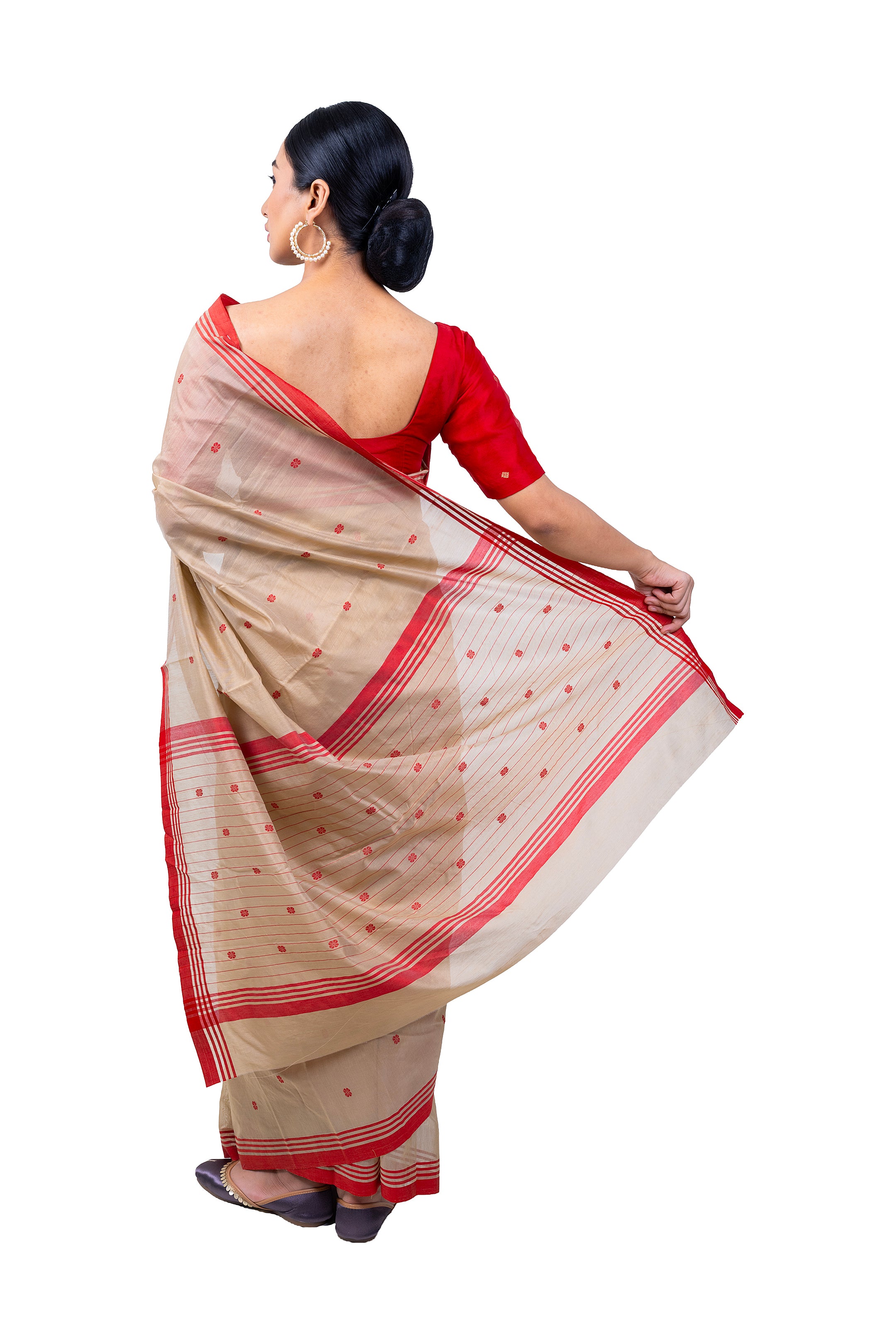 Woman wearing a beige and red saree with a white background