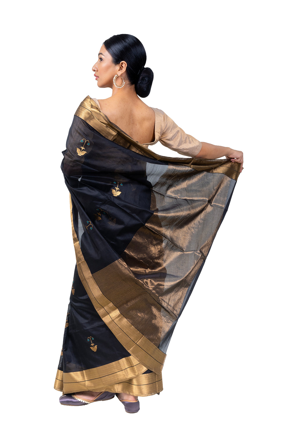 Woman wearing a black and gold saree on a white background