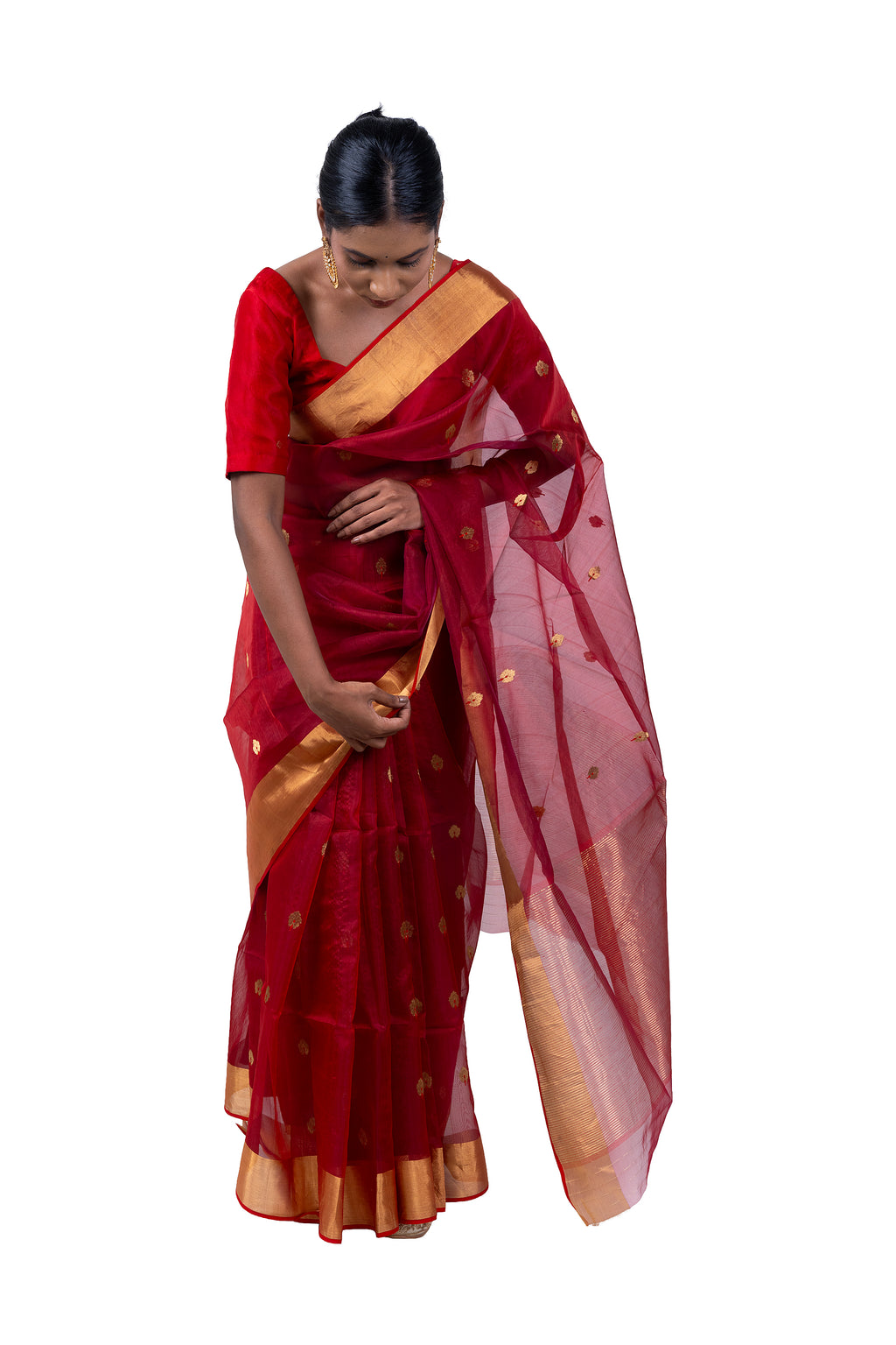 Woman wearing a red saree with gold border on a white background