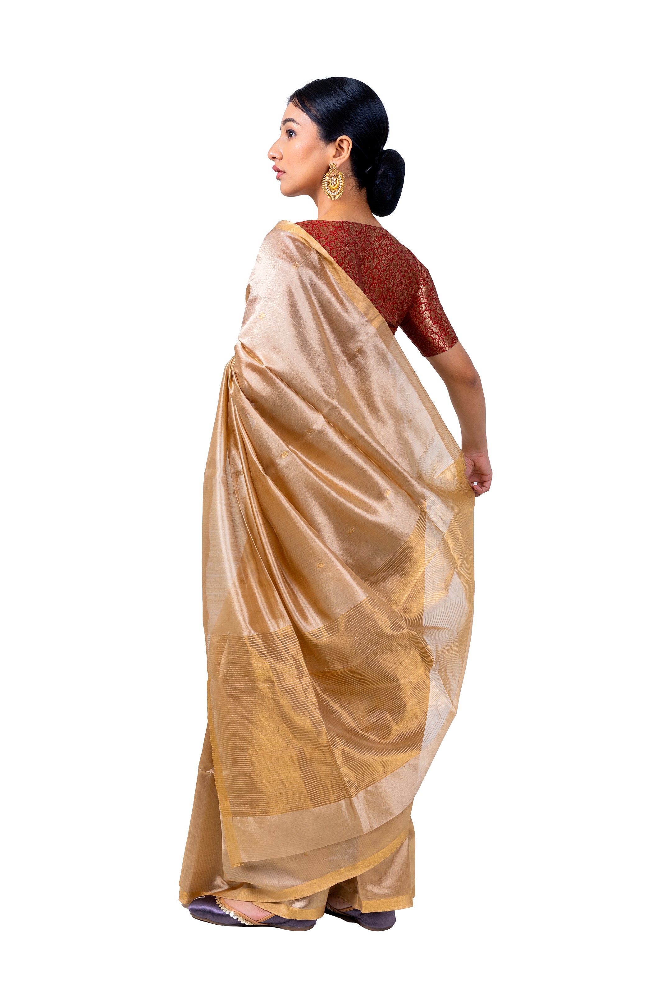 Woman wearing a beige saree with a white background