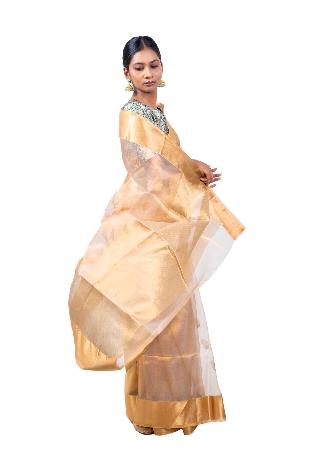 Woman wearing a traditional beige saree with a white border on a white background