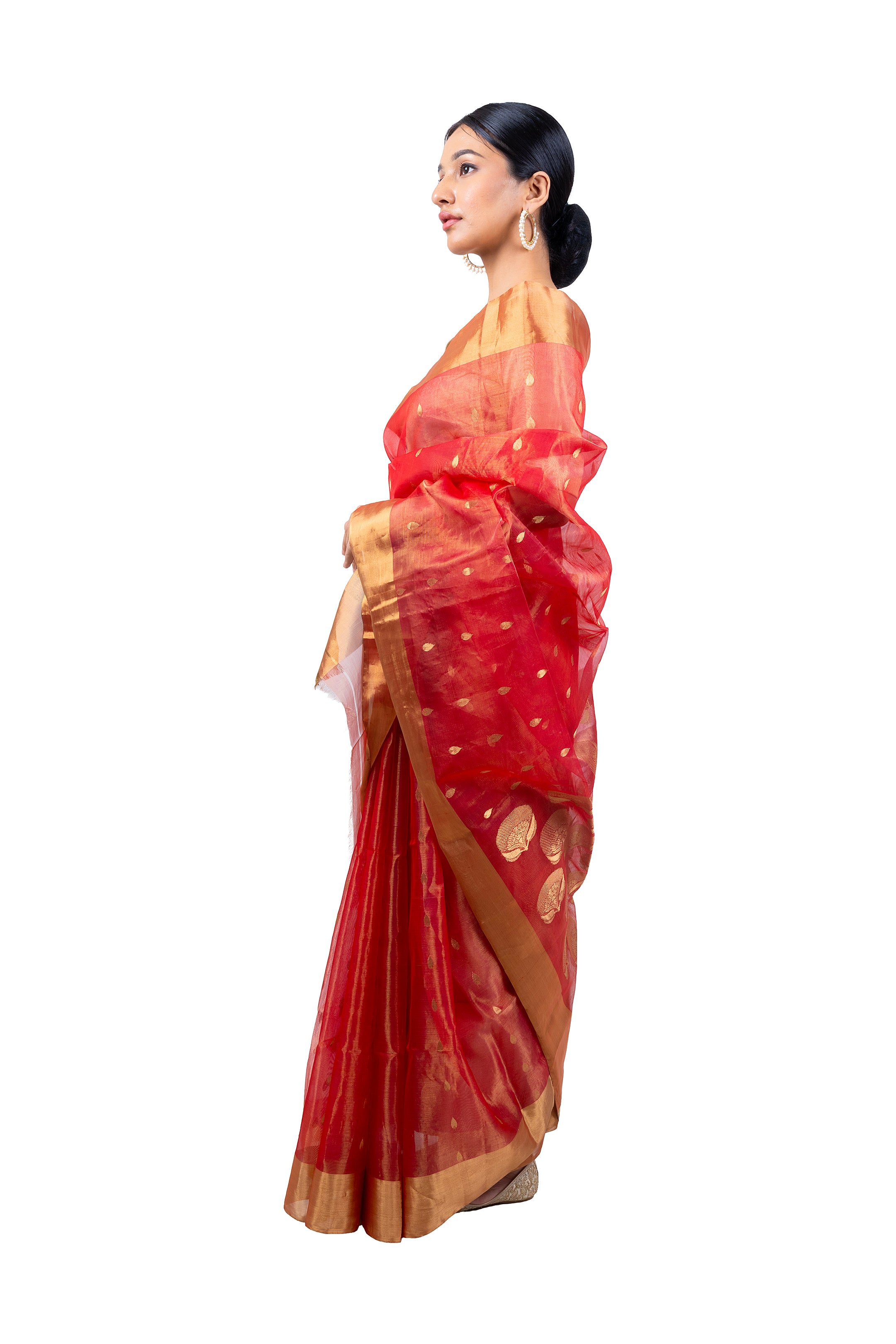 Woman wearing a red saree with gold border on a white background