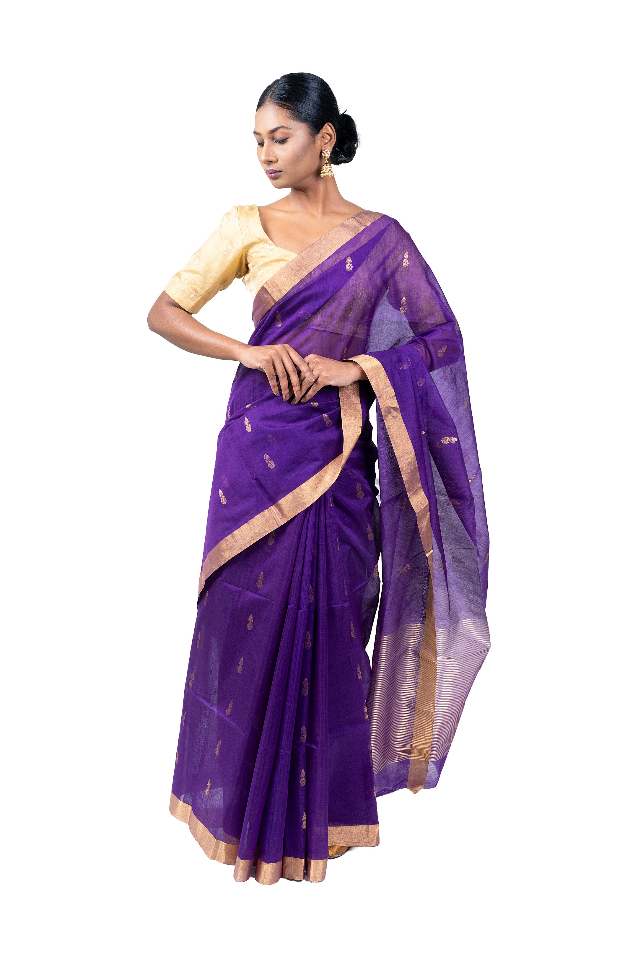 Woman wearing a purple saree with gold border on a white background