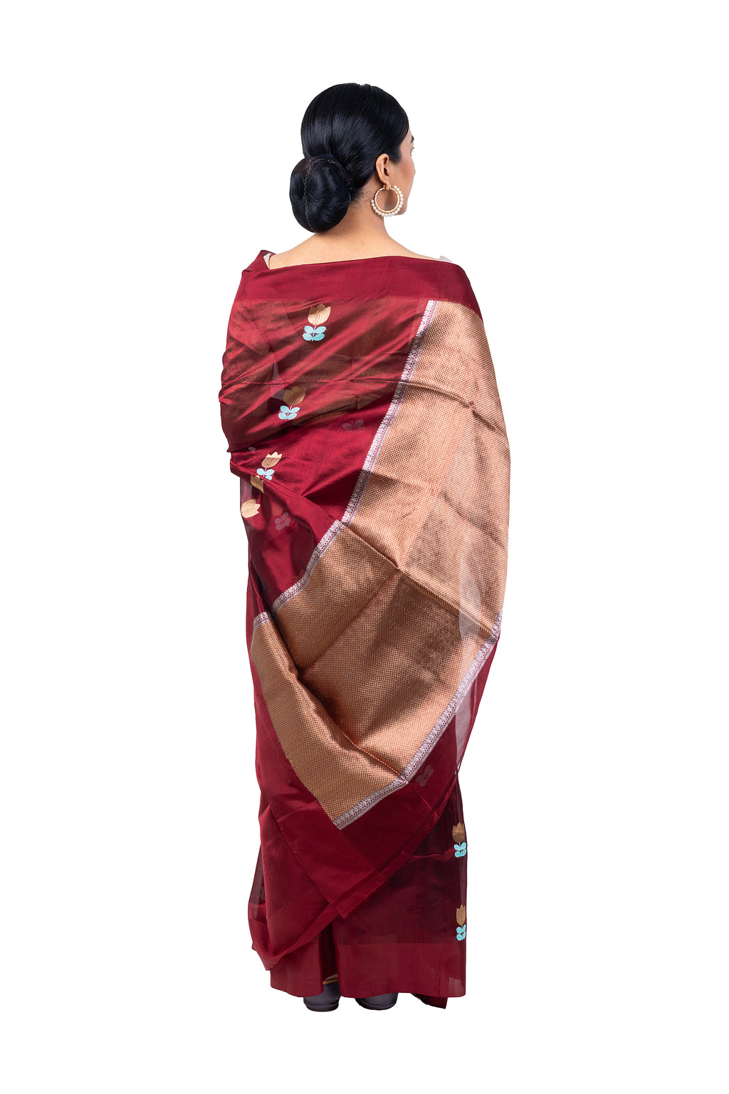 Woman wearing a maroon saree with a beige border on a white background