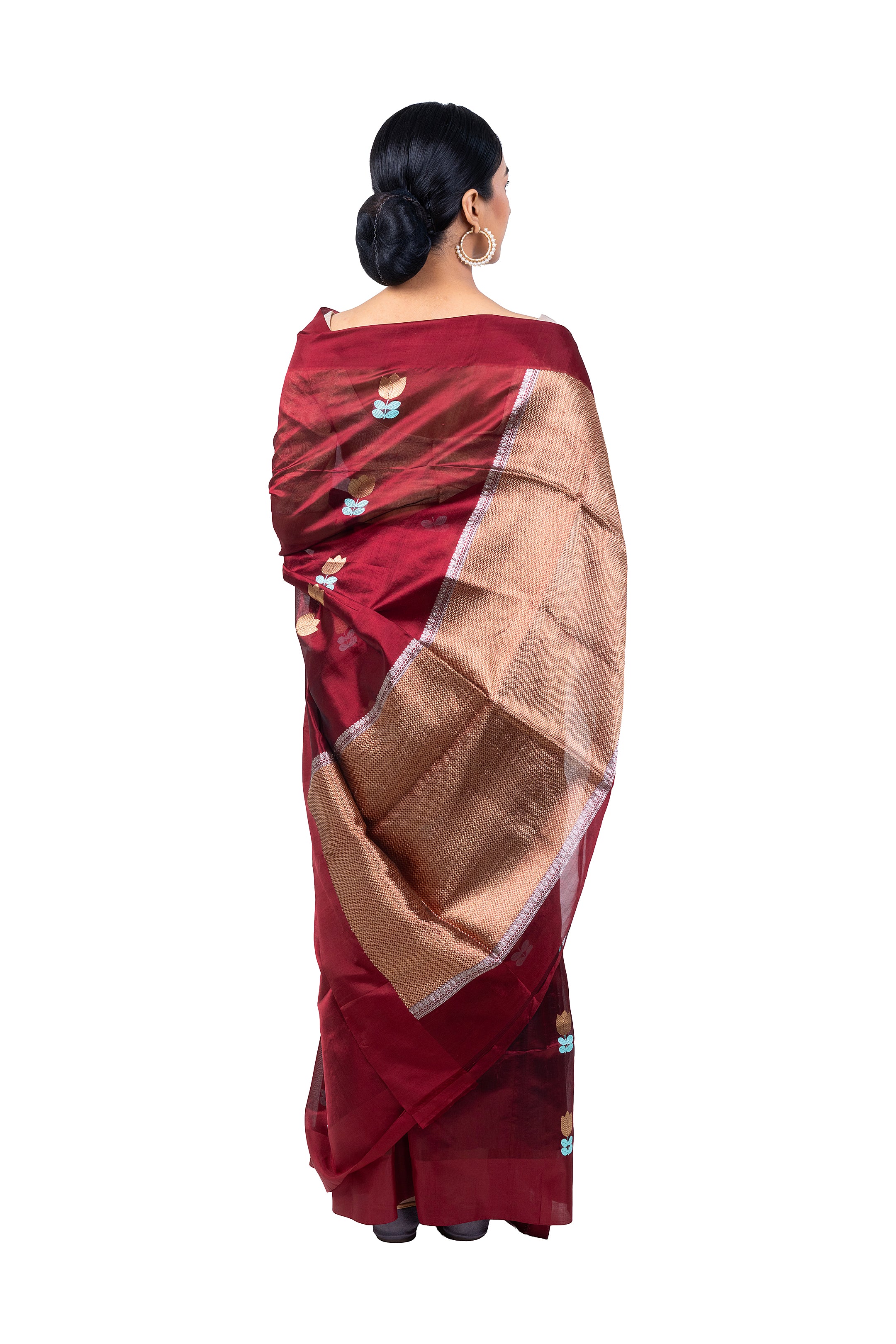 Woman wearing a maroon saree with a beige border on a white background