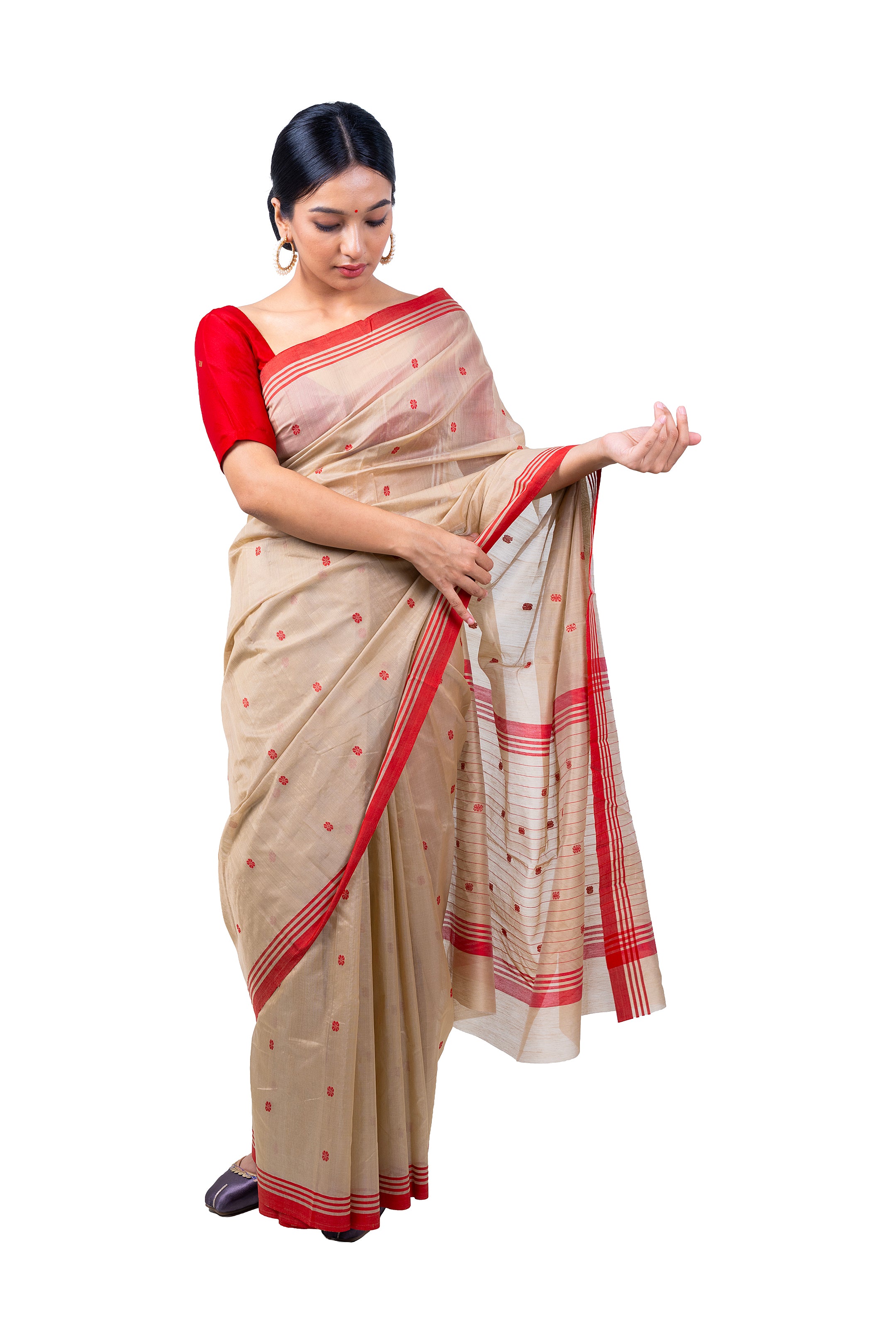 Woman wearing a beige saree with red accents on a white background