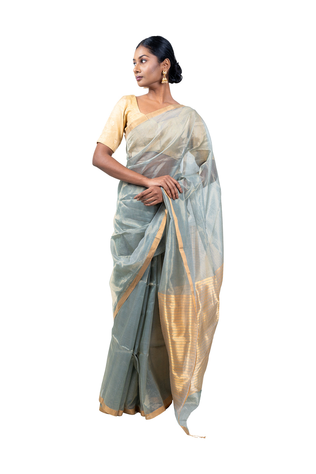 Woman wearing a light gray saree with a white background