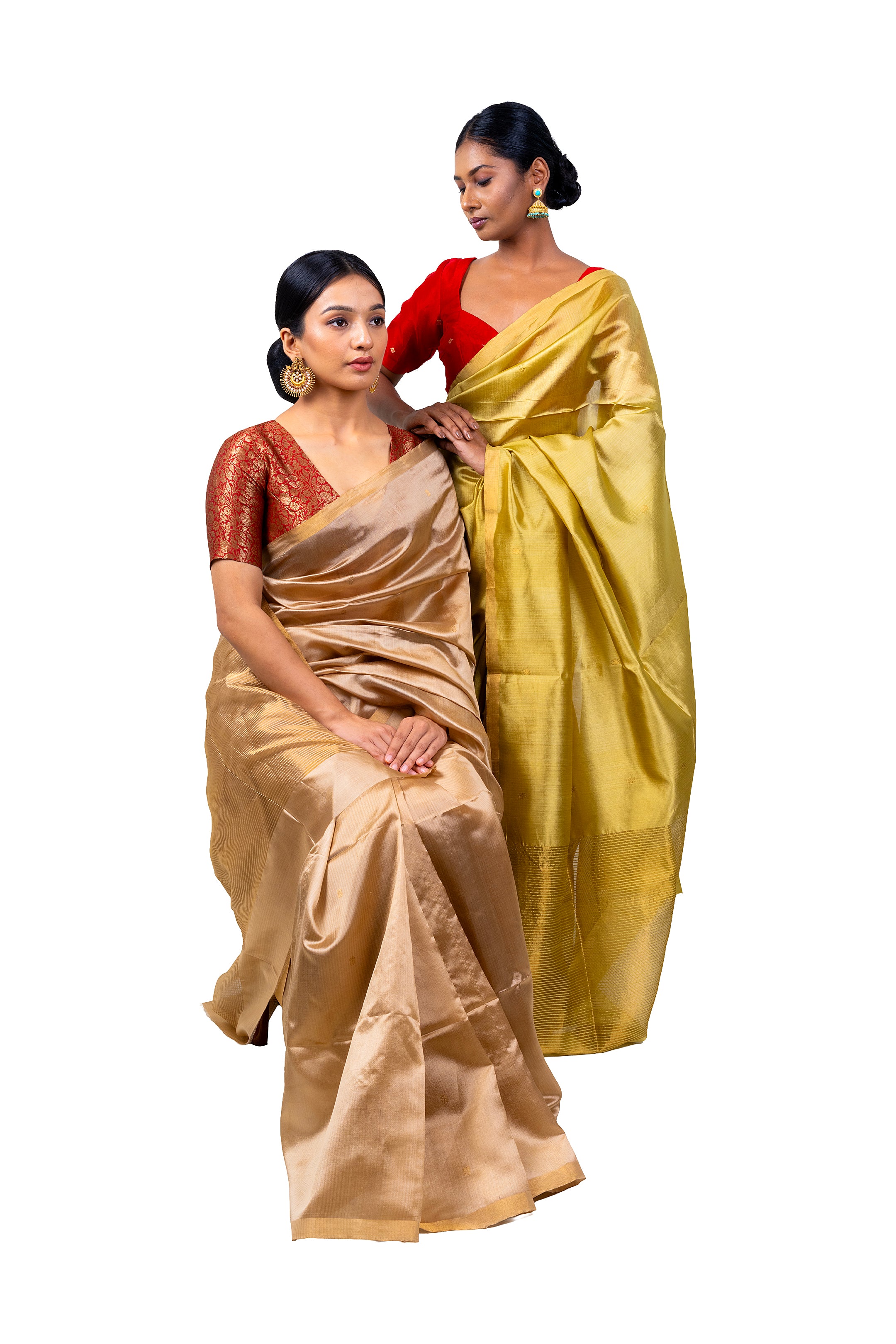 Two women wearing traditional sarees on a white background