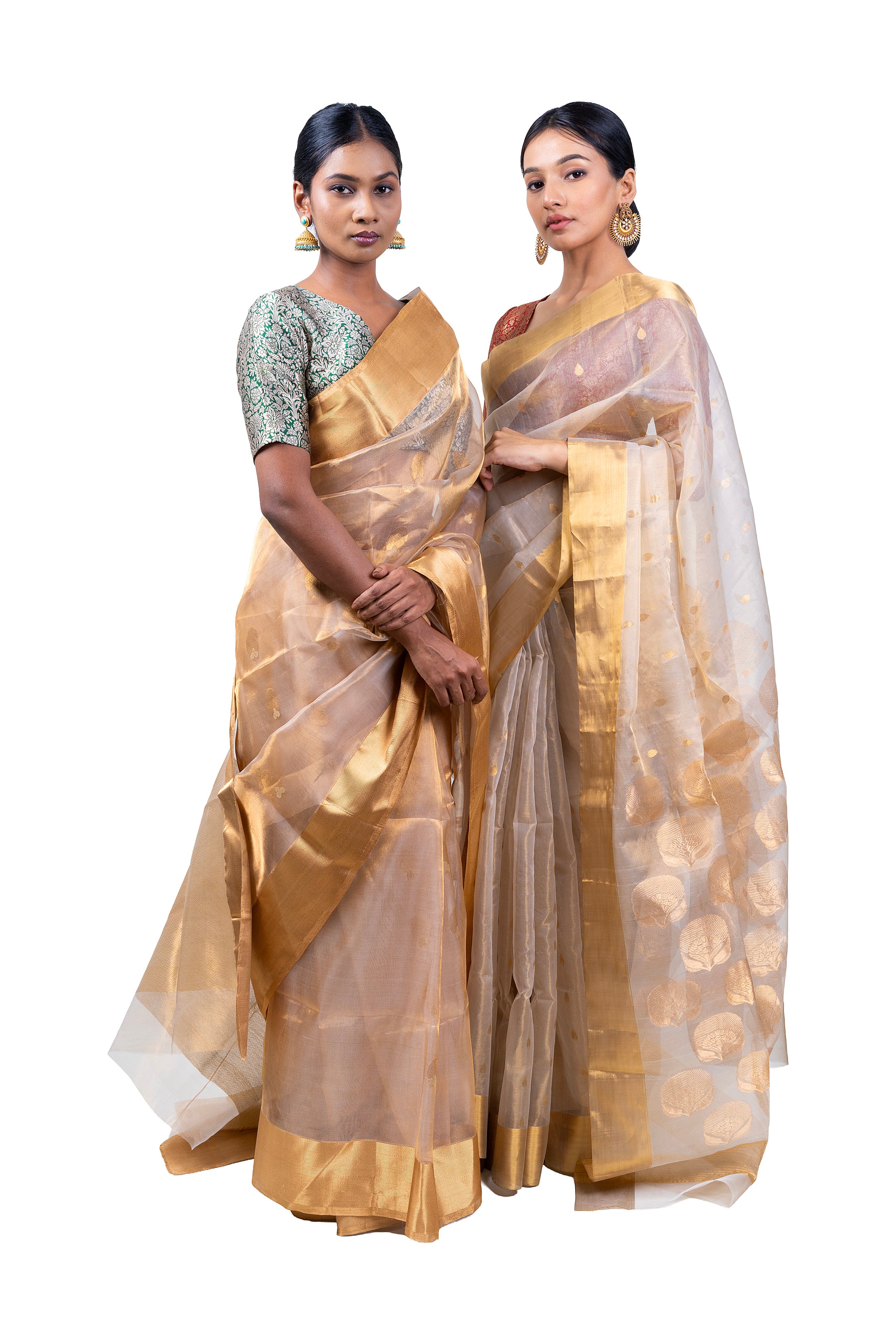 Two women wearing gold sarees with white borders on a white background