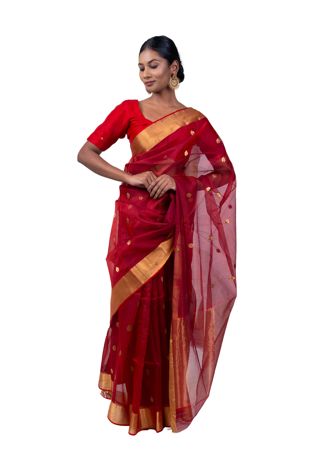Woman wearing a red saree with gold border on a white background