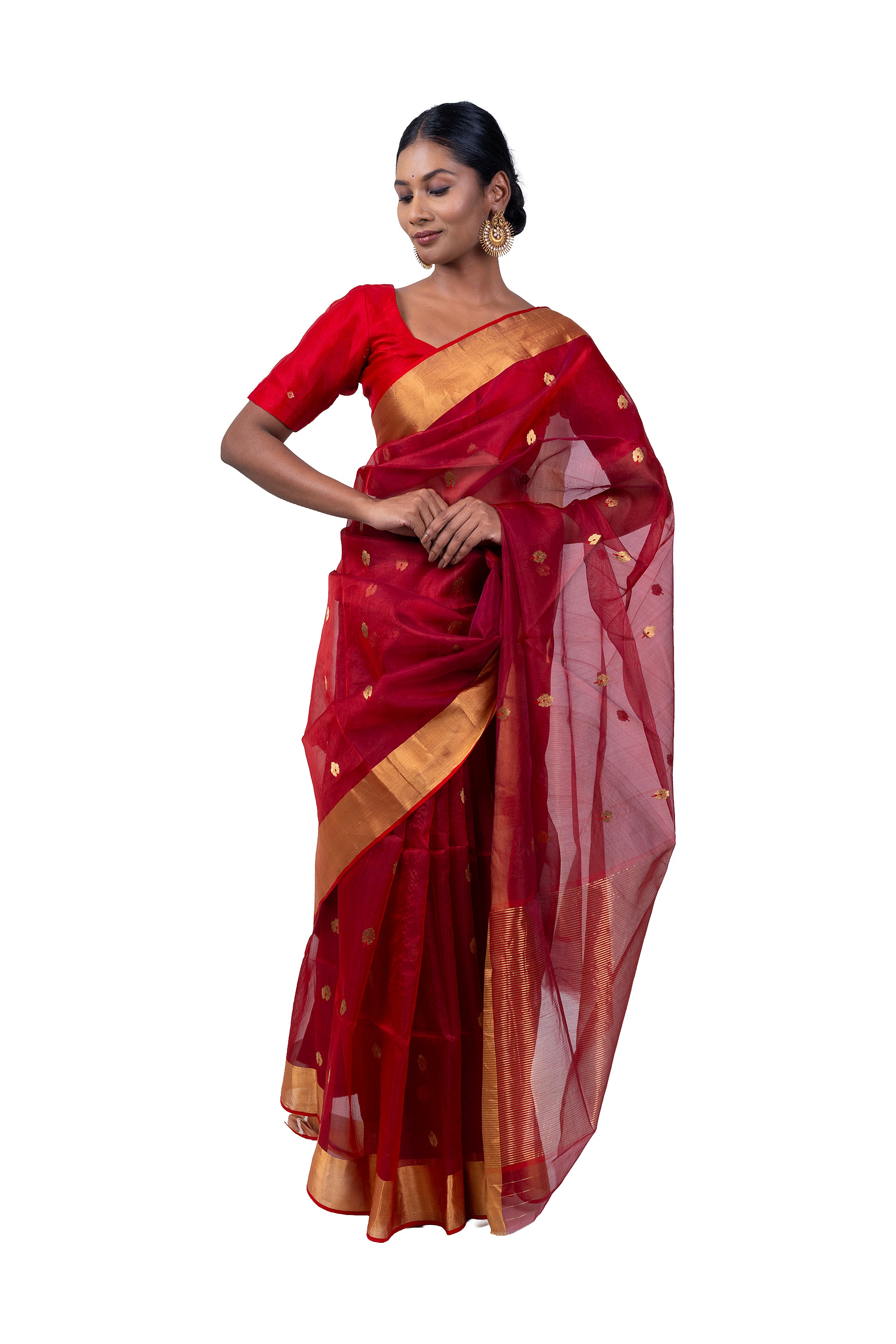 Woman wearing a red saree with gold border on a white background